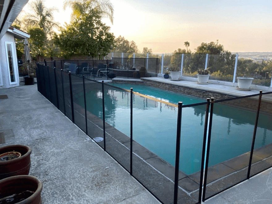 black mesh pool fence installed around a rectangular swimming pool