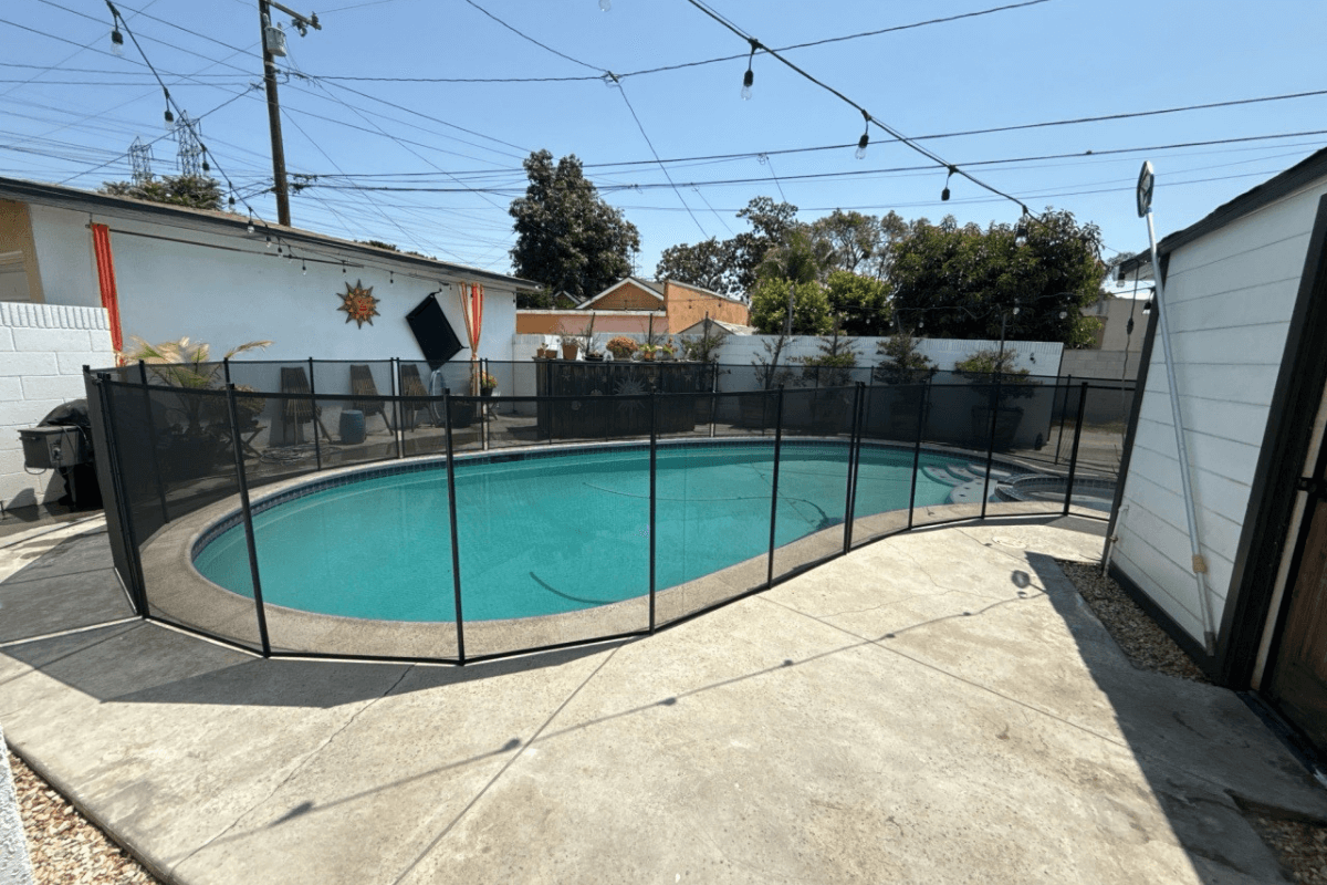 backyard pool and safety fence swimming pool with black mesh pool fence surrounding it